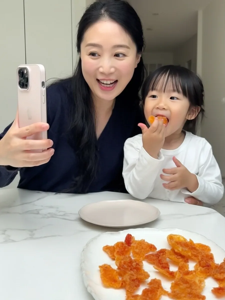 아이와 함께 간식을 맛보며 촬영하는 엄마 크리에이터
